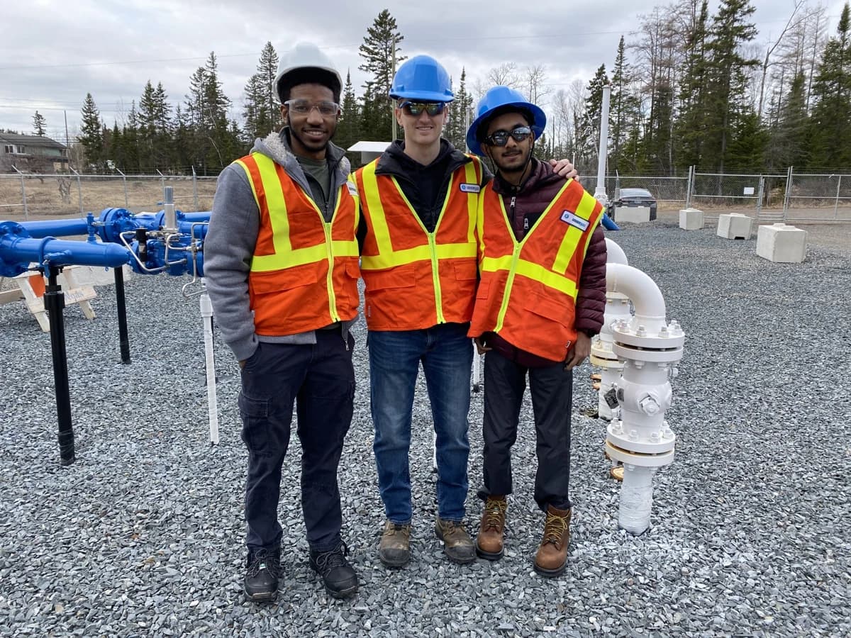 Kaleel and two colleagues in safety equipment at an engineering field site