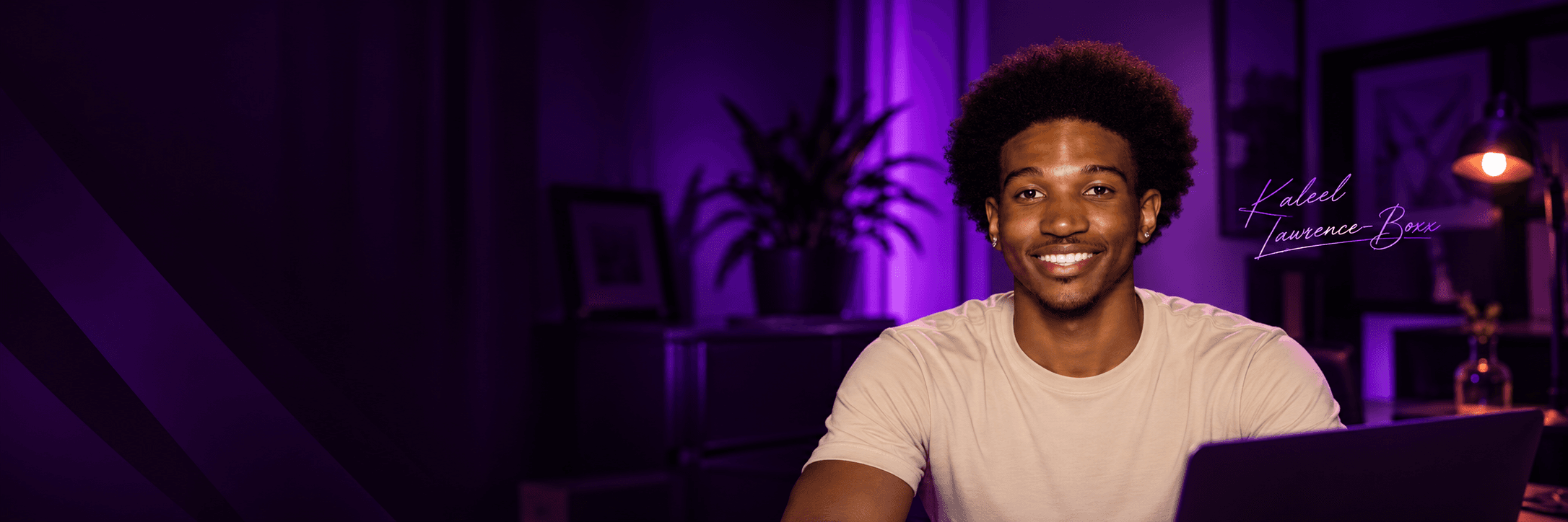 Kaleel Lawrence-Boxx in a purple-lit workspace, with his signature beside him